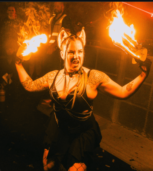 SIN FIRE performer holding two flaming torches